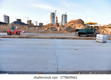 Paving Roller Machine During Road Work. Road Roller At Construction Site For Paving Works. Screeding The Sand For Road Concreting. Asphalt Pavement Is Layered Over Concrete Pavement