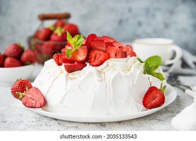 Pavlova cake with meringue and fresh strawberries on a light background, selective focus, close up