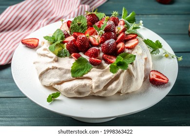 Pavlova Meringue Cake Decorated With Fresh Strawberries And Whipped Cream. Food, Culinary, Baking And Cooking Concept.