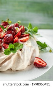 Pavlova Meringue Cake Decorated With Fresh Strawberries And Whipped Cream. Food, Culinary, Baking And Cooking Concept.