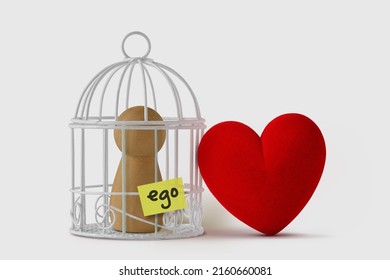 Pawn in a bird cage with the word Ego written on paper note and free heart  - Love and ego concept