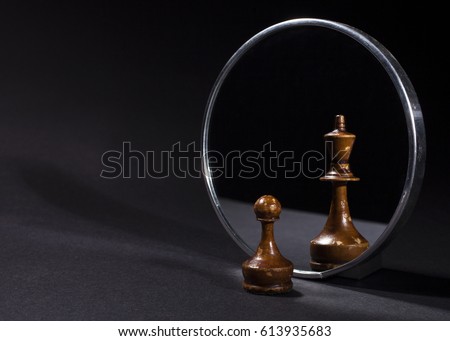 Pawn looking in the mirror and seeing a king. Black background. Сток-фото © 