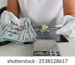 Pawn shop checks a large diamond in a ring and holds the money in dollars. Customers buy and sell precious metals and gems and jewelry