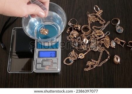 pawnshop worker determines the ring of gold jewelry using the Hydrostatic weighing method by Archimedes' law, evaluation of gold items in a pawnshop, fake gold, concept