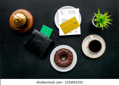 Pay The Bill, Pay At Restaurant. Check Near Wallet, Bank Card, Service Bell, Coffee On Black Background Top View Copy Space