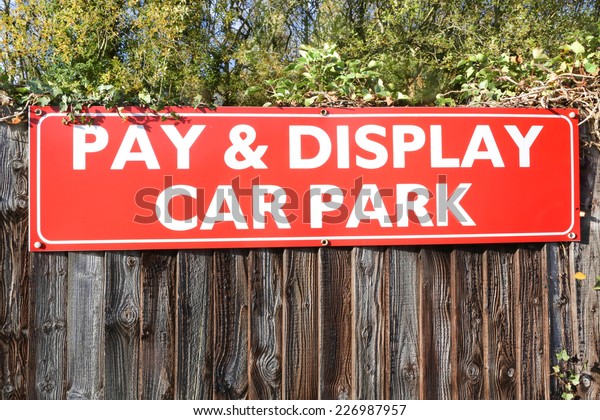 Pay and
Display car parking sign on a wooden
fence.