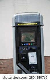 pay and display parking machine with a button-based interface and digital screen. The user enters vehicle registration details, selects parking duration with plus and minus controls, and confirms payment using the green tick button. The scene represents modern urban parking management and self-service technology.
