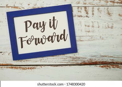 Pay It Forward Written With Blue Photo Frame Flat Lay On Wooden Background