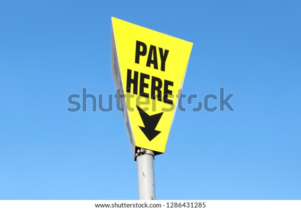 Pay here sign\
for car parking against blue\
sky