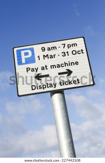 Pay at machine car
park sign when parking between 9am and 7pm, March to October
against a partly cloudy
sky.