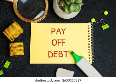 Pay off debt concept. Process of repaying borrowed money, including the principal amount and any accrued interest, to creditors or lenders. Notepad, coins and markers on the table