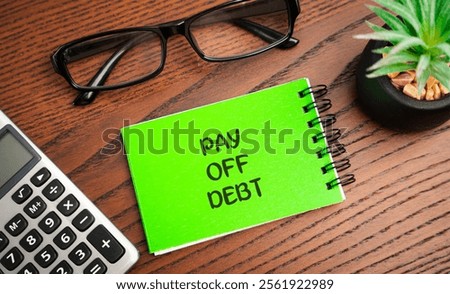 Pay off debt concept. Process of repaying borrowed money, including the principal amount and any accrued interest, to creditors or lenders. Notebook, calculator and glasses on the table