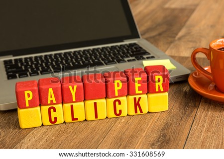 Pay Per Click written on a wooden cube in front of a laptop