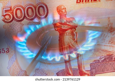 Pay for Russian gas in roubles concept. Russia Sanctions and Ukraine war concept. Blue gas burning from a kitchen gas stove with Russian 5000 roubles bank note.