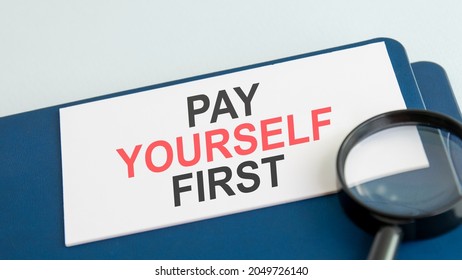 Pay Yourself First Word On White Paper Card And Magnifying Lens