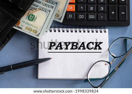 PAYBACK - word in a notebook against the background of money, glasses and calculator. Business and finance concept