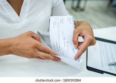 Paycheck In Open Envelope. Holding Payroll Cheque