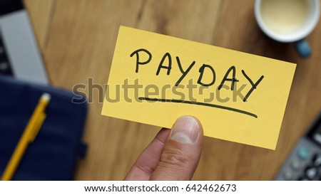 Payday written on a card at workingplace in business setting                         