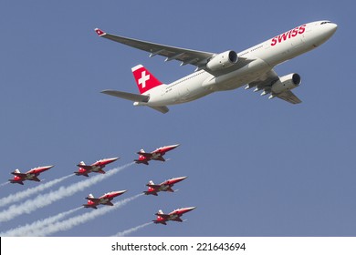 PAYERNE, SWITZERLAND - SEPTEMBER 6: Flight of Airbus A-330 and Patrouille Suisse team on AIR14 airshow in Payerne, Switzerland on September 6, 2014