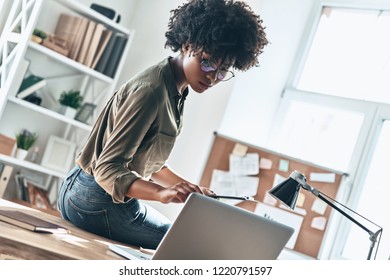 Paying Attention To Every Detail. Thoughtful Young African Woman Writing Something Down While Working In The Office