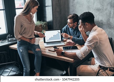 Paying Attention To Every Detail. Top View Of Young Confident Business People Analyzing Data Using Computer While Spending Time In The Office