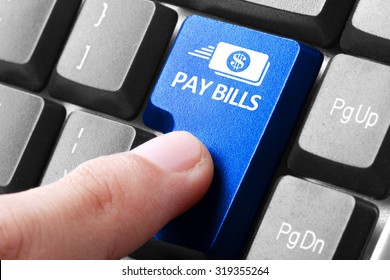 paying bills. gesture of finger pressing pay bills button on a computer keyboard