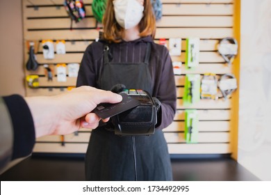 Paying With A Credit Card At A Small Local Shop. Store Assistant Holding Payment Terminal At A Bike Shop, Point Of View Shot