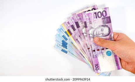 Paying of multiple Philippine Peso 1000 bills on white background	