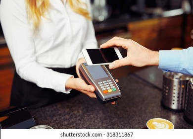 Paying With Smartphone. Closeup Of Man Making Payment Transaction With His Mobile Phone