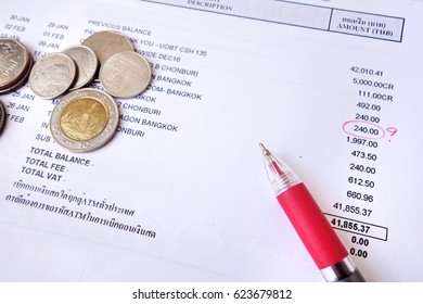 payment bill with red pen and coins.