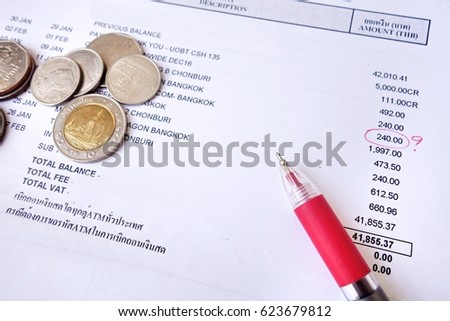 payment bill with red pen and coins.