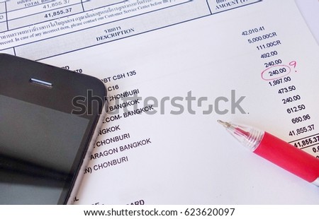 payment bill with red pen and phone.