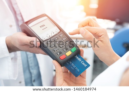 Payment by credit card with terminal. Woman enters the pin code