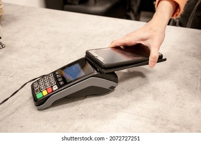Payment by phone via the store's terminal - Shutterstock ID 2072727251