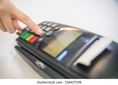 Payment Card In A Bank Terminal. The Concept Of Of Electronic Payment. Hand Pin Code On Pin Pad Of Card Machine Or Pos Terminal Good Photo