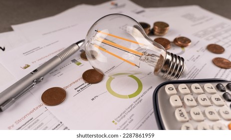 Payment invoice, light bulb and calculator, eurocement. Increase in electricity prices. Translation ''Renewable energies, financed by EEG-umlage, other renewable energies''