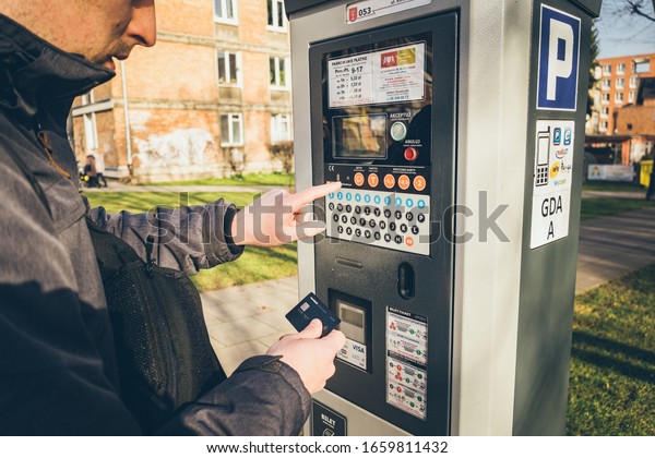 Payment for parking in the City of Gdansk, Poland\
on February 8, 2020. A person uses monobank credit card for nfc\
payment in parking terminal. Paid Automatic payment for parking\
places in city.