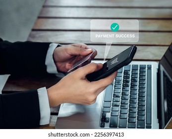 Payment success concept. Money transfer confirmed with payment success, words and cart icon showing on mobile smart phone in businessperson's hand who holding  a credit card for online shopping. - Shutterstock ID 2256397413