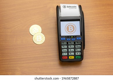 Payment Terminal Ready To Accept Bitcoins For Payment. There Are Bitcoin Coins On The Table Nearby