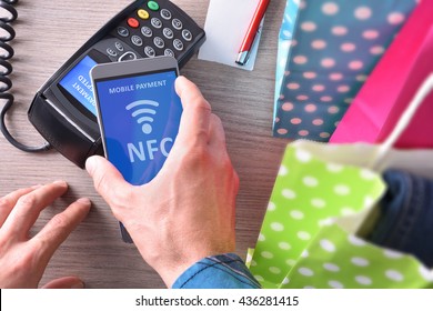 Payment in a trade with nfc system with mobile phone. Top view,vertical composition