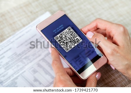 payment of utility bills by QR code without leaving the house, using a smartphone, the girl makes an on-line payment. Scanning Two-Dimensional Code with Mobile Phone 