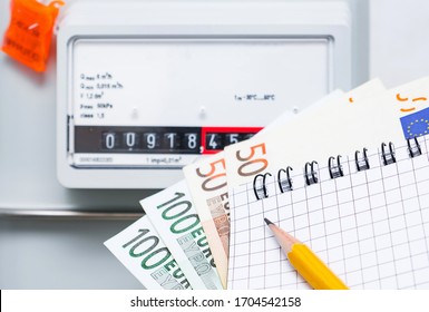 Payment Of Utility Services, Concept Image. Notebook With Euro Bills On The Background Of A Gas Meter