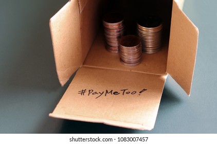 #PayMeToo As A New Campaign To Close The Wage Gap Between Men And Women. A Pile Of Coins In An Open Paper Box.