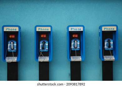 Payphones line a blue wall in Cayman Islands