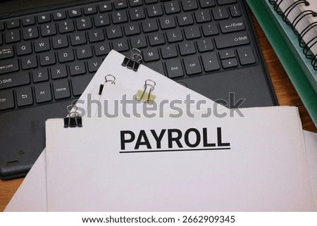 Payroll Document on Keyboard With Notebook in Office Desk Setup
