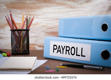 Payroll, Office Binder On Wooden Desk. On The Table Colored Pencils, Pen, Notebook Paper