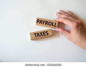 Payroll Taxes Symbol. Concept Word Payroll Taxes On Wooden Blocks. Beautiful White Background. Businessman Hand. Business And Payroll Taxes Concept. Copy Space