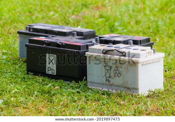 Pb lead car\
batteries on a grass in the\
nature