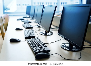 Pc computer workspaces in a row for creative workers, programmer or students in a computer lab, selected focus, narrow depth of field