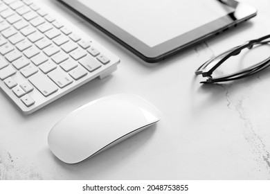 PC mouse, keyboard and tablet computer on table